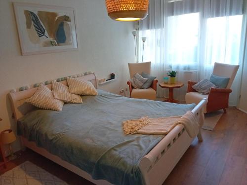 莱利斯塔德Oudaen 36的一间卧室配有一张大床和两把椅子