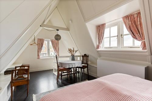 WestzaanBoutique Hotel Jongwijs Westzaan的卧室配有一张床和一张桌子及椅子