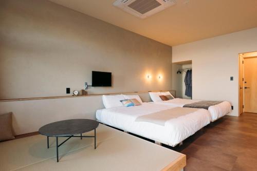 长崎长崎漫步之家旅馆的酒店客房设有两张床和一张桌子。
