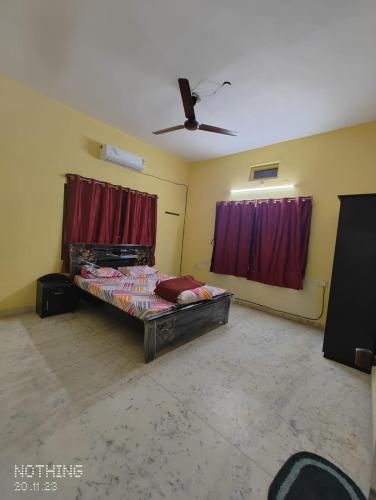 海得拉巴S A Villa的一间设有床铺的卧室,位于一间设有红色窗帘的房间