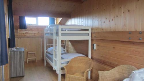 劳雷尔苏格Boothuis Lauwersoog的小屋内带两张双层床的客房