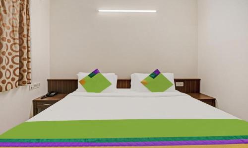 班加罗尔Hotel Prime Pavilion-MG ROAD的卧室配有白色的床、色彩缤纷的床单和枕头。