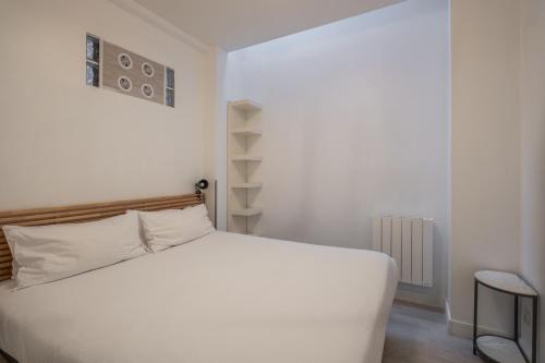 巴黎克里南柯特公寓酒店的卧室配有白色的床和架子