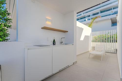 阿坎提拉德洛斯基Luxury triplex + pool, jacuzzi - SissiPark Azul的白色的厨房配有柜台和椅子
