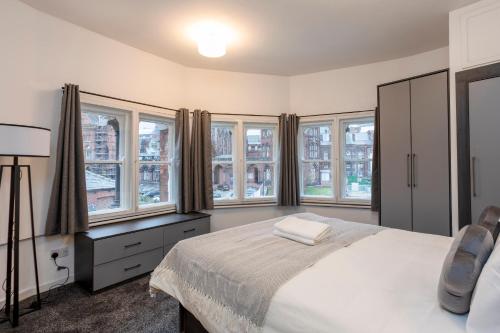 利兹Oxford Row Apartments, Leeds City Centre的一间卧室设有一张床和一些窗户。
