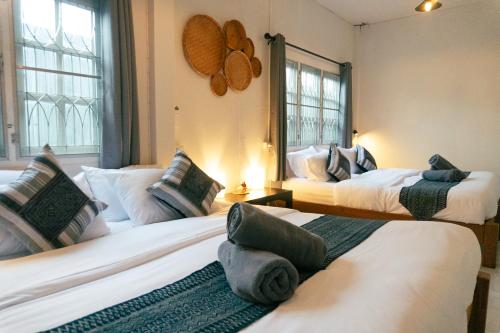 清迈Baan Ragang : Cozy Entire House in Old Chiang Mai的带三张床和两扇窗户的房间