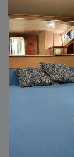 萨莱诺Salerno Yacht的一间卧室配有一张带枕头和镜子的床