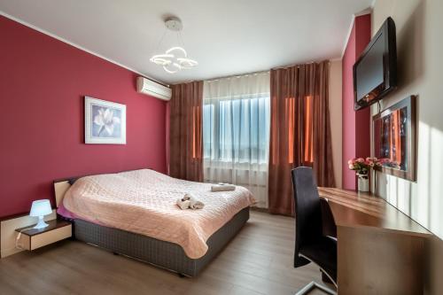 普罗夫迪夫罗西娜公寓的一间卧室配有一张床、一张书桌和一台电视