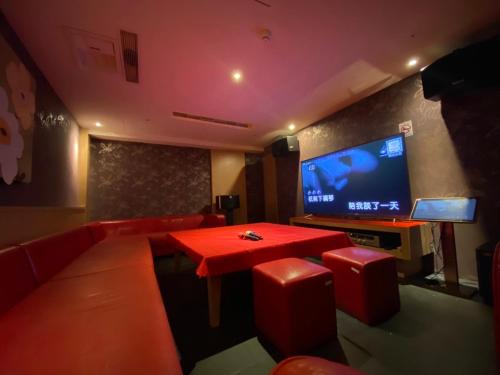 垦丁大街垦丁南国之梦-原垦丁俪山林会馆 的客厅配有红色桌子和平面电视。