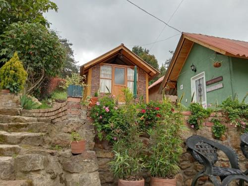 蒙圭Hospedaje - Cabañas villa rosita的一座小房子,设有石墙和长凳