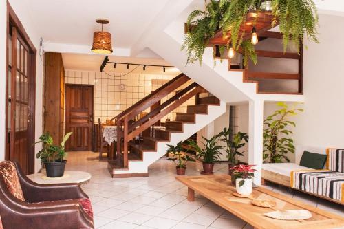 弗洛里亚诺波利斯Nômades Beach Hostel的客厅设有楼梯和盆栽植物