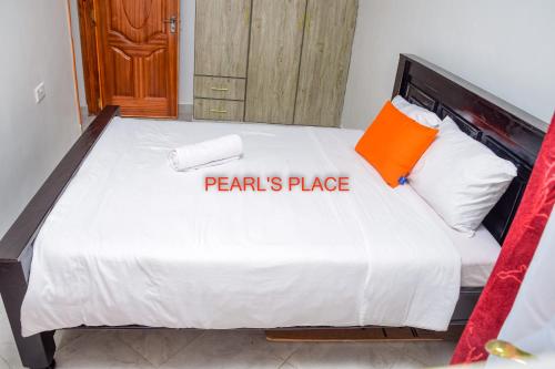 MeruPearl's Place的一间卧室配有一张带橙色枕头的大床