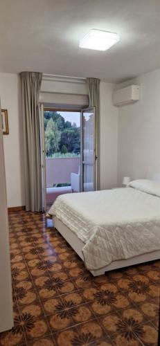 罗马Casa Stazione Magliana的一间卧室设有一张床和一个滑动玻璃门