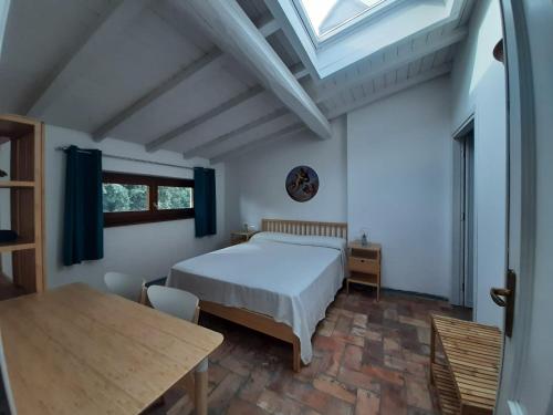 维泰博Agriturismo la Romanella的一间卧室配有一张床、一张桌子和一个窗户。