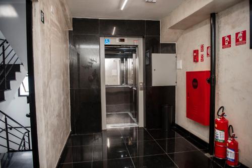 圣保罗Uny Hotéis Brás的一间带步入式淋浴间和红色门的浴室