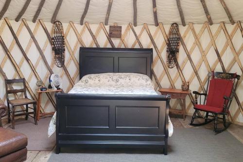 BrownfieldRufus III Yurt on the river的蒙古包内一间卧室,配有一张黑色的床