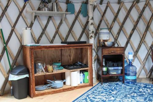 BrownfieldAllie Mae Yurt nestled in the woods的圆顶帐篷内的木架和桌子