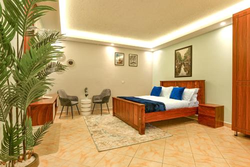 坎帕拉Premier Suites Kyanja的卧室配有一张床、一张桌子和椅子