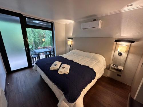 康塞普西翁Cabaña Habitainer BordeRio 3的一间卧室配有一张床,上面有两条毛巾