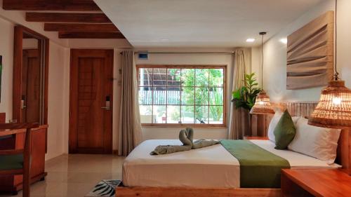 长滩岛Senare Boracay Hotel的一间卧室设有一张大床和一个窗户。