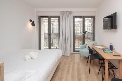 巴黎FINESTATE Coliving Champs-Elysées的白色卧室配有书桌、床、桌子和椅子