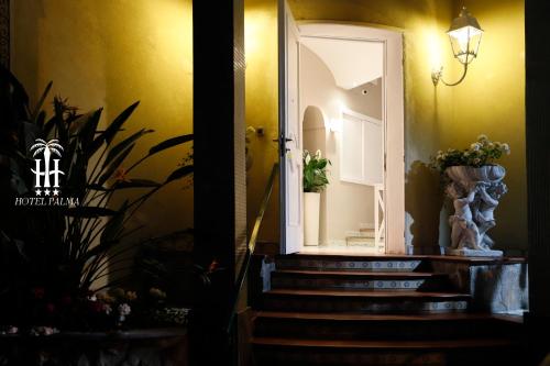 卡斯特拉玛雷帝斯达比亚Hotel Palma的走廊设有楼梯,门上设有镜子