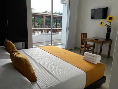 Paz de AriporoHOTEL EXBINT RESORT的一间卧室配有一张带窗户和桌子的床
