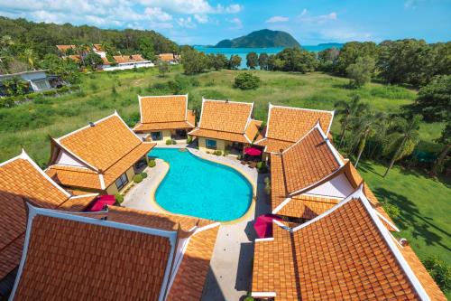 拉威海滩Phuket Kana International Hotel普吉岛卡娜国际酒店的享有带游泳池的房屋的空中景致