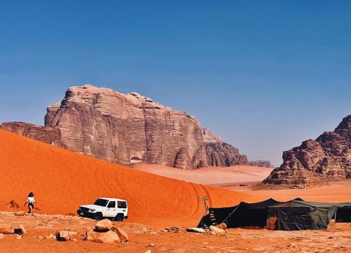 瓦迪拉姆Bedouin bunch camp的沙漠中的帐篷和面包车