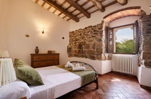 卡隆赫Masia Torre Lloreta S.XIII的一间卧室设有一张床和一个窗口