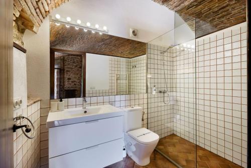 卡隆赫Masia Torre Lloreta S.XIII的一间带卫生间、水槽和镜子的浴室