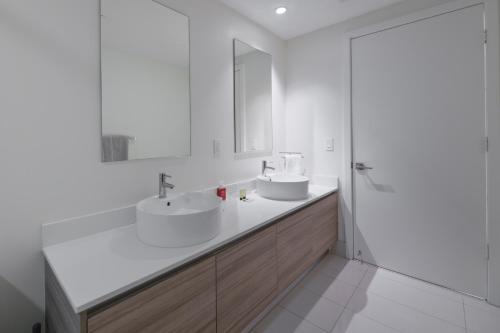 迈阿密Unwind in Your Amazing City View Apartment的白色的浴室设有两个盥洗盆和镜子