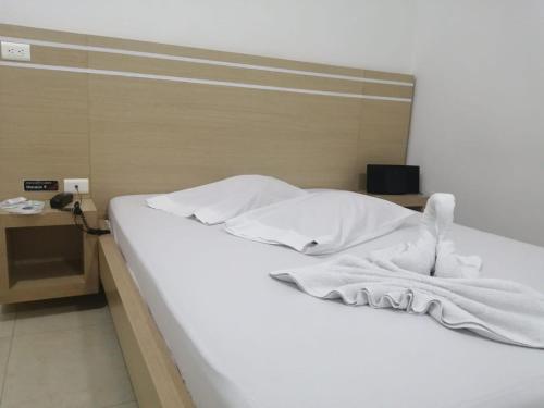 帕尔米拉MOTEL CUPIDO (PALMIRA)的一张带白色床单和毛巾的床