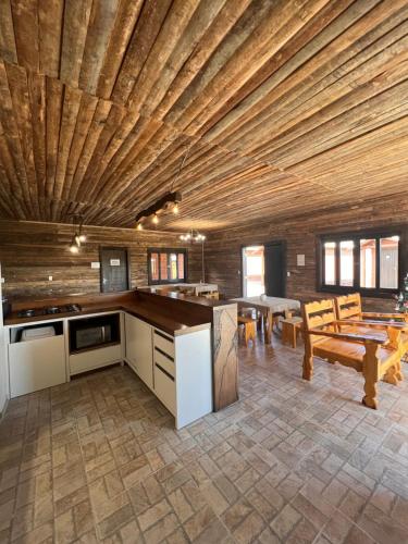 坎巴拉Pousada Costaneira的一间厨房和带木制天花板的用餐室