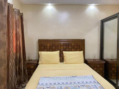达喀尔Residence Adja Binta Kane Sour的卧室内的一张带木制床头板的床