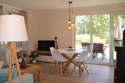 马林费尔德U17 EG - komfortable Ferienwohnung mit Terrasse, Wlan und Kamin的客厅配有桌椅和电视。