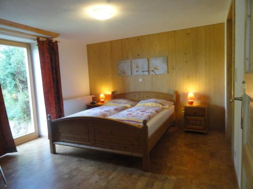 米尔施塔特兰德博纳文图拉公寓的一间卧室配有木床和两盏灯