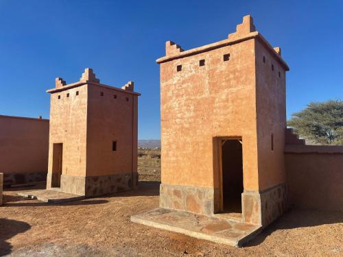 NkobMagical Berber Camp的沙漠中一座建筑的两座塔