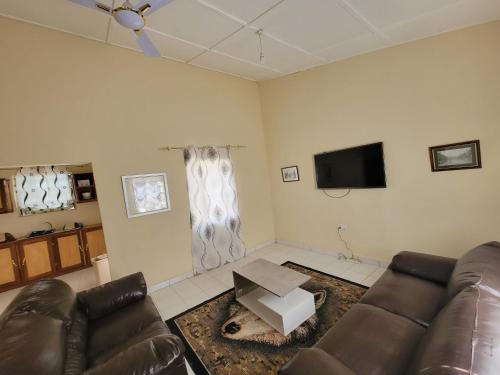 YundumNicely Furnished Comfortable Holiday Apartment Home at Yarambamba Estate的带沙发和电视的客厅