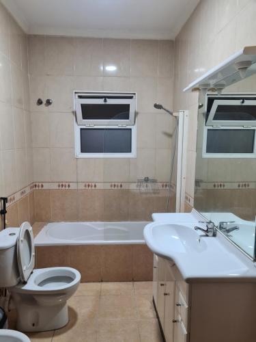 马普托Pastello guest house的带浴缸、卫生间和盥洗盆的浴室