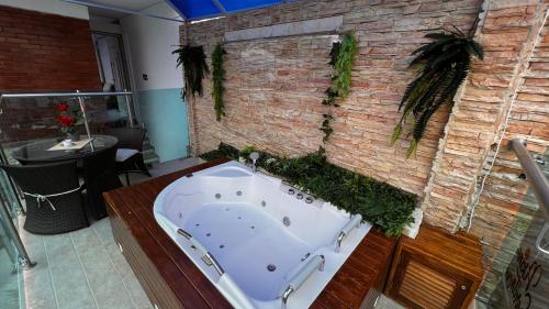 吉拉尔多特PISCINA SARITA CLUB BOUTIQUE的砖墙客房内的浴缸
