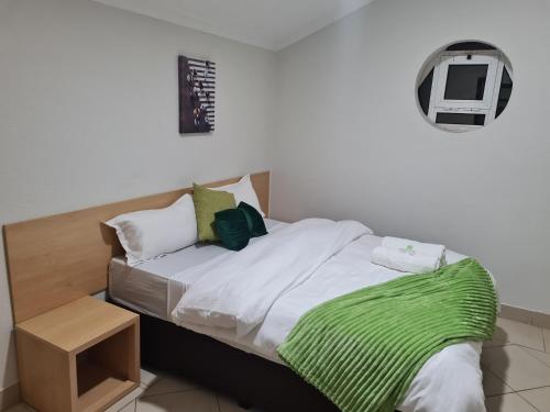 马普托Pastello guest house的一间卧室配有一张带绿毯的床