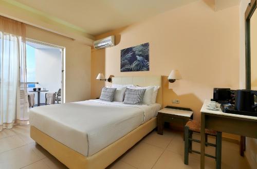 锡西Sissi Bay Resort的一间卧室配有一张床和一张书桌及电视