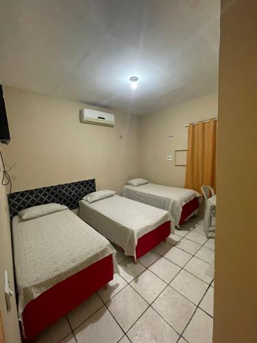 特雷西纳Hotel Horizonte的酒店客房设有两张床和窗户。
