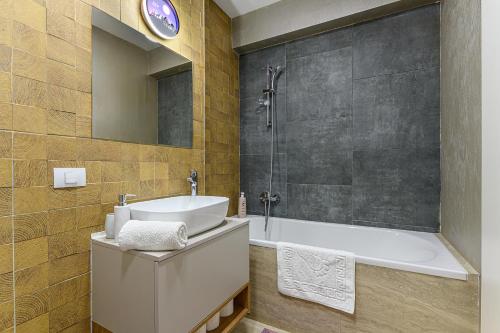 布拉索夫Grandis Residence Apartment的带浴缸、水槽和淋浴的浴室