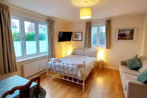 莱姆里吉斯No 4 suite的一间卧室配有一张床、一张沙发和窗户。