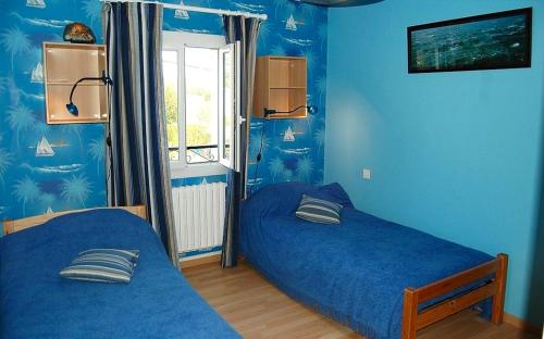 卡斯泰尔诺－蒙特拉蒂耶Maison de 4 chambres avec vue sur la ville jacuzzi et jardin clos a Castelnau Montratier的一间卧室设有两张床,拥有蓝色的墙壁。
