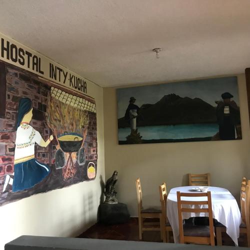 奥塔瓦洛Intykucha的一间设有桌子和墙上绘画的用餐室