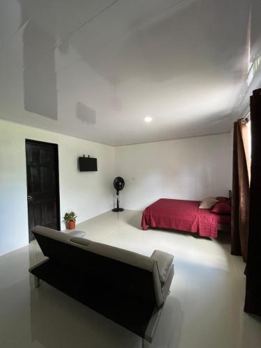 希门尼斯港Corcovado House With AC的一间卧室配有一张床和一张红色的四柱床。