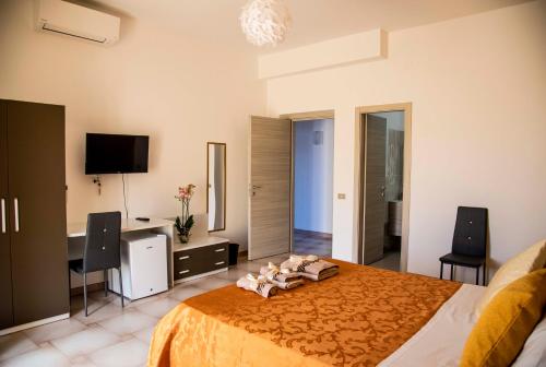 兰佩杜萨Blu Mare Lampedusa Bed And Breakfast的一间卧室配有一张床、一张书桌和一台电视